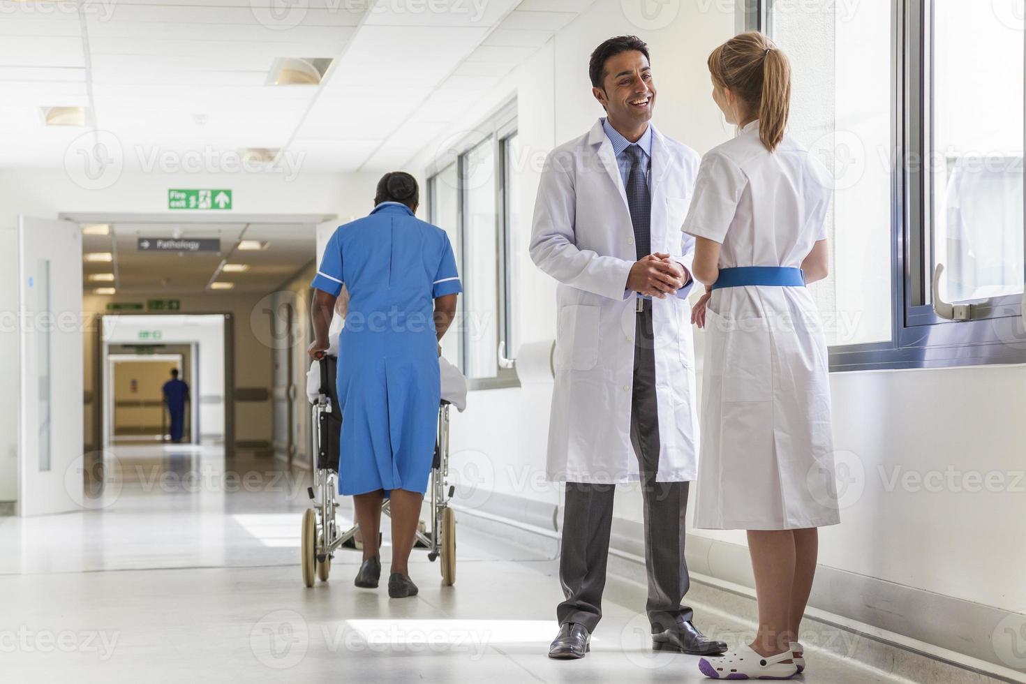 médicos hospital corredor enfermeira empurrando cadeira de rodas foto