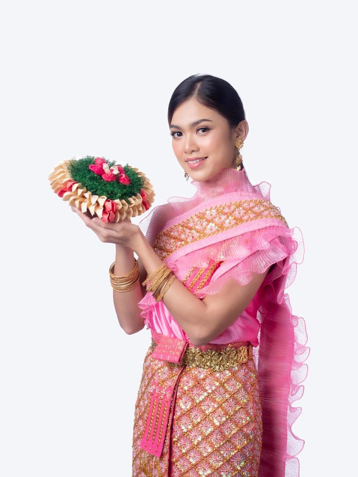 atraente mulher tailandesa vestida com roupas tradicionais tailandesas detém uma cesta de flores foto