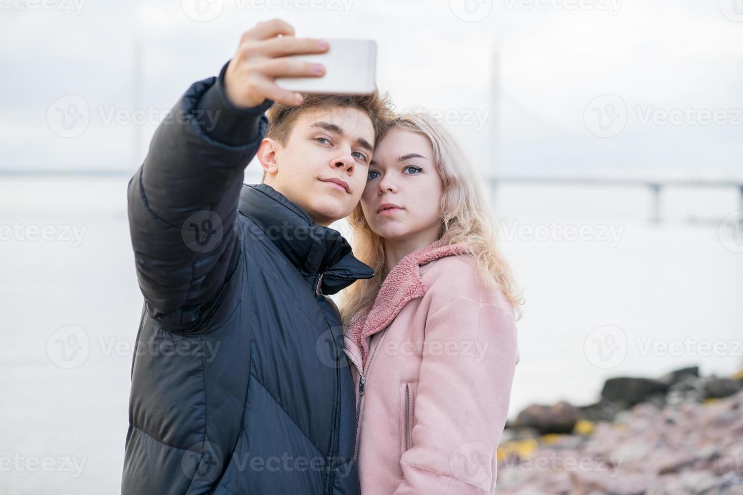 conceito de amor adolescente. lindo cara morena jovem loira foto