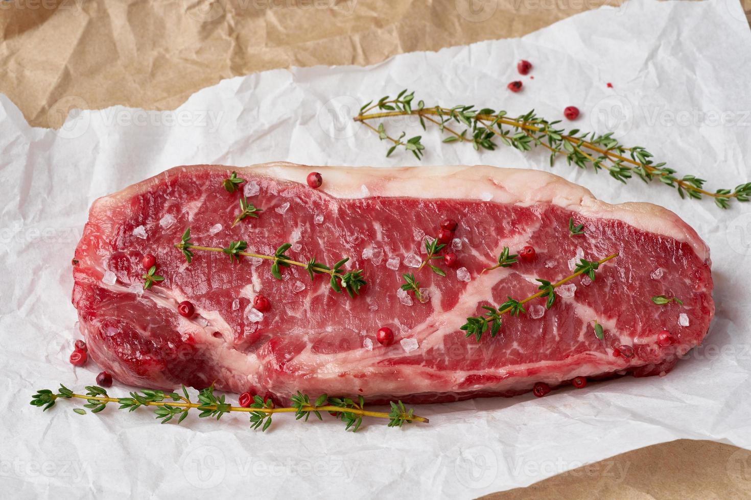 grande pedaço inteiro de carne de bovino crua, contrafilé em papel manteiga branco foto