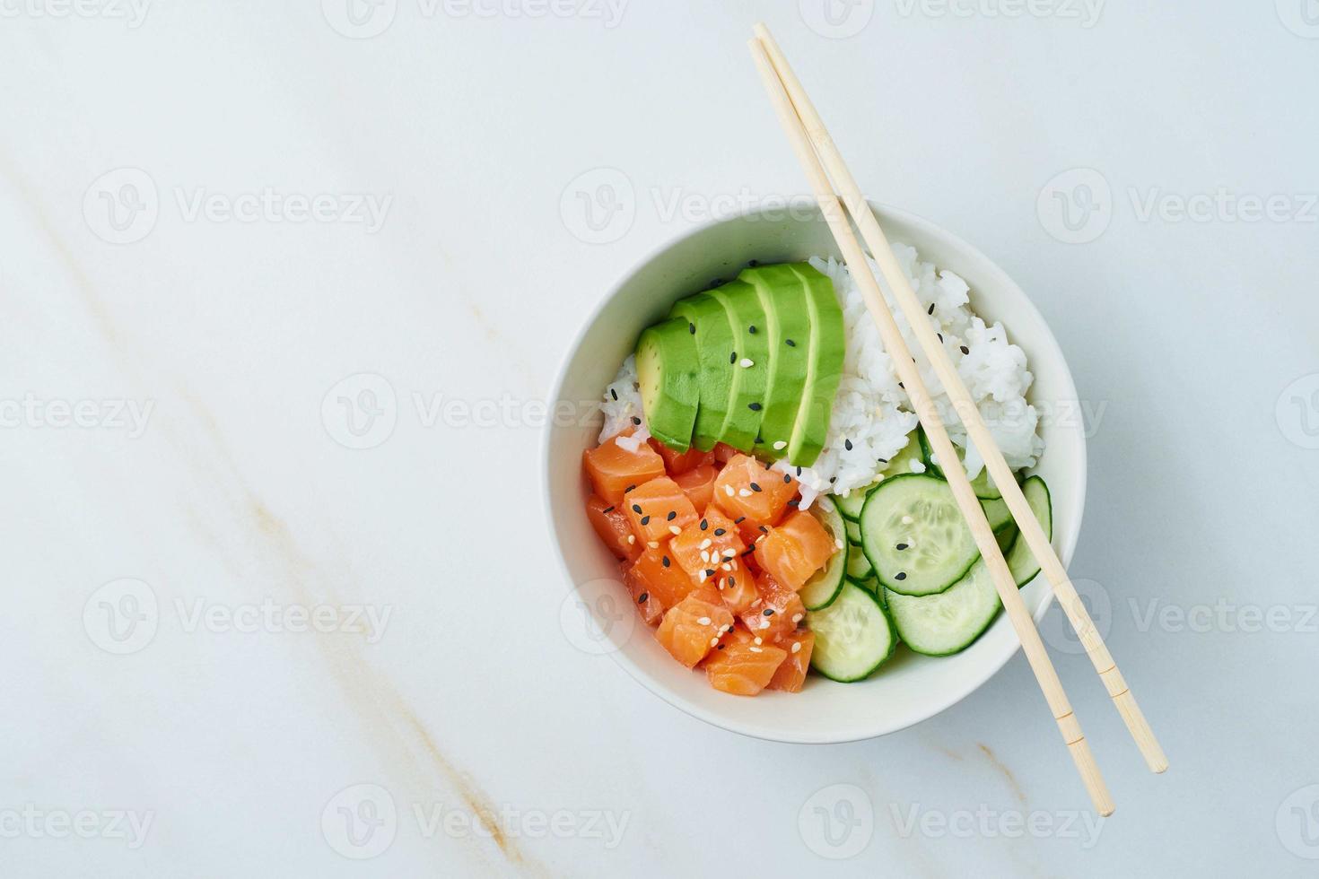 tigela de salmão com peixe fresco, arroz, pepino, abacate foto