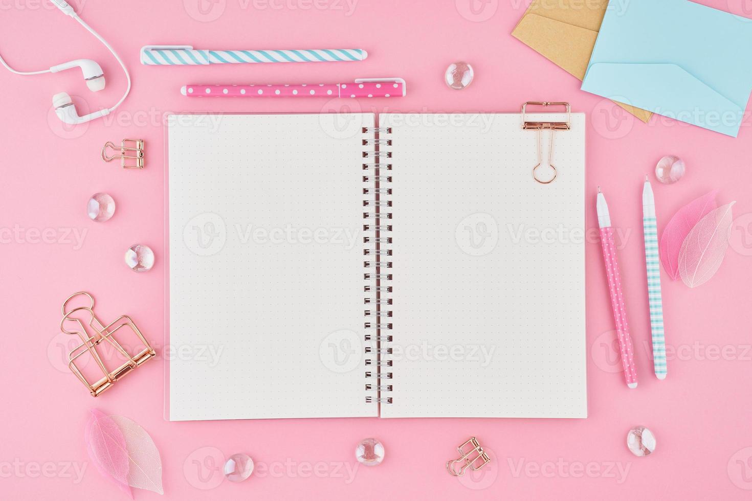 página do bloco de notas em branco no diário de bala na área de trabalho do escritório rosa brilhante. vista superior da mesa brilhante moderna com notebook, artigos de papelaria. mock up, copie o espaço, conceito para diário foto