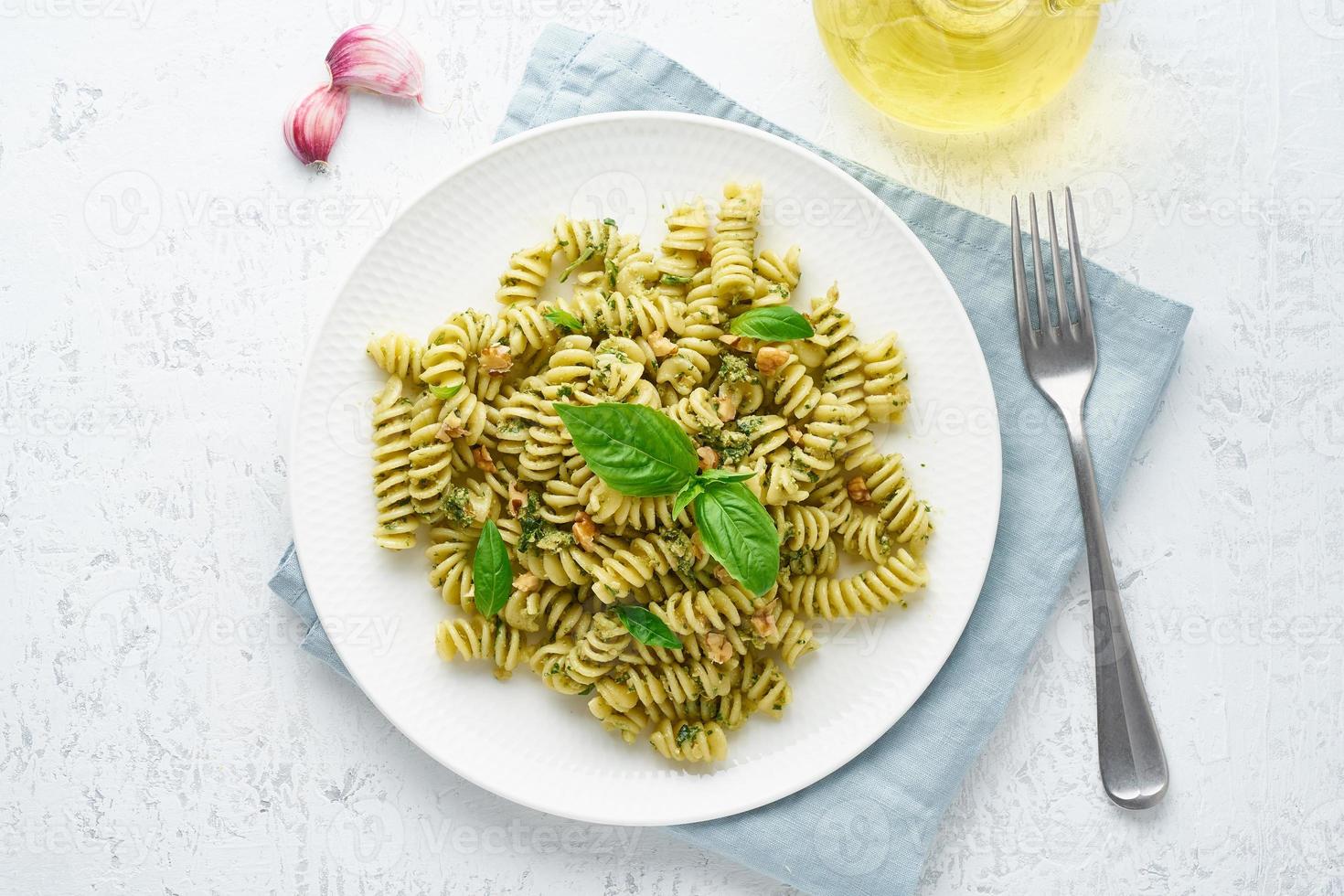 massa fusili com pesto de manjericão e ervas, cozinha italiana, fundo de pedra cinza, vista superior foto