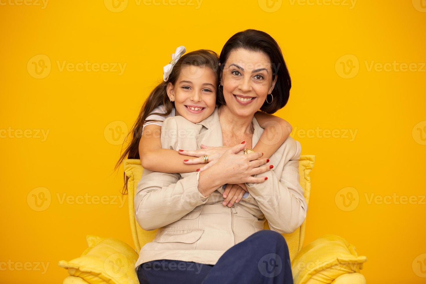 feliz dia das mães close-up retrato de linda, encantadora mãe e filha com sorrisos radiantes sobre fundo amarelo. filha abraçando a mãe em fundo amarelo. foto