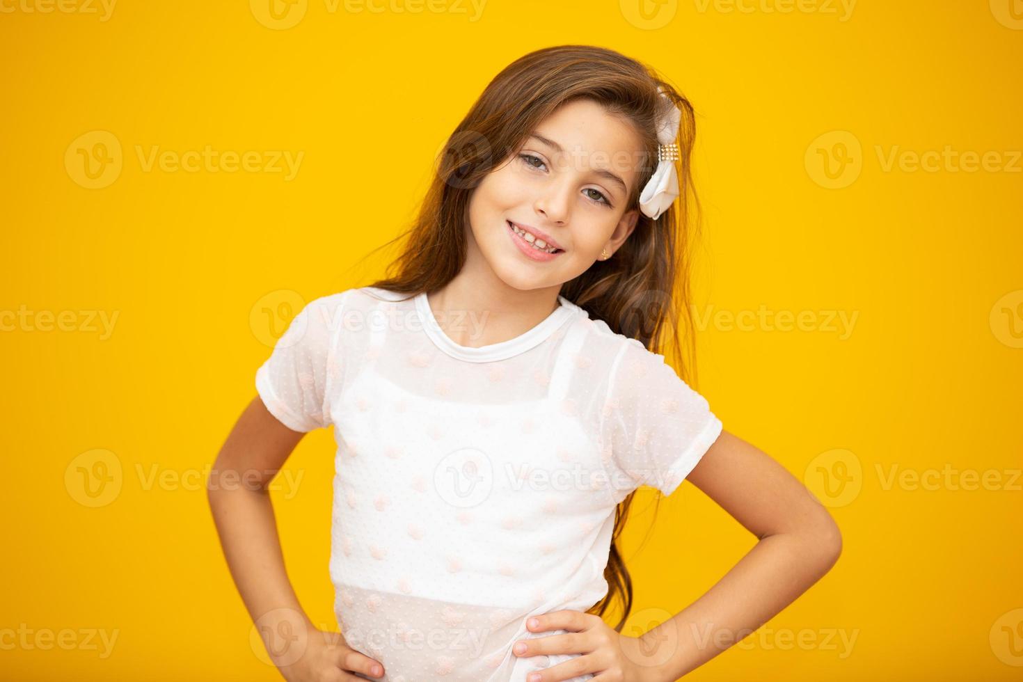 retrato de uma menina criança sorridente feliz em fundo amarelo. foto