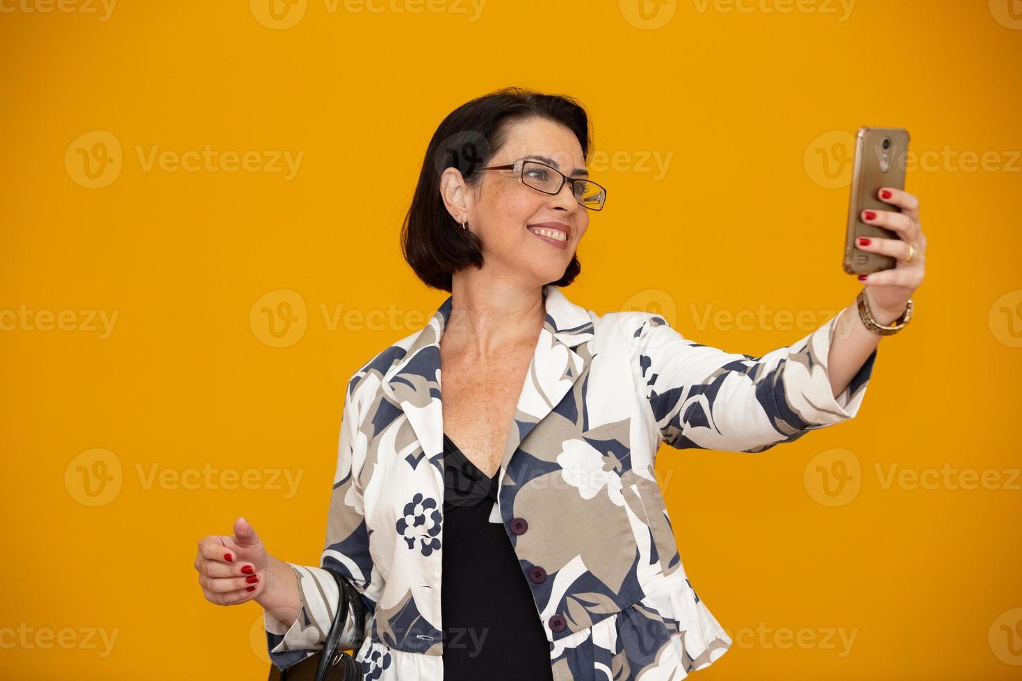 selfie de mulher de negócios. mulher bonita sênior com telefone celular foto