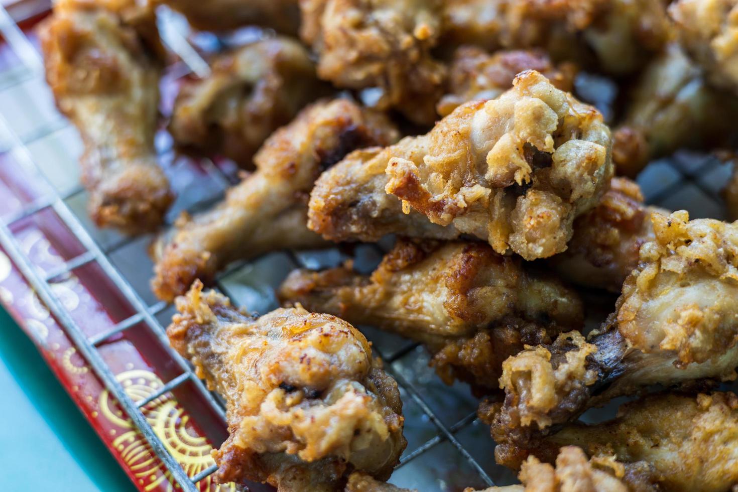 muitos pedaços de coxinhas de frango estão empilhados na grelha. foto