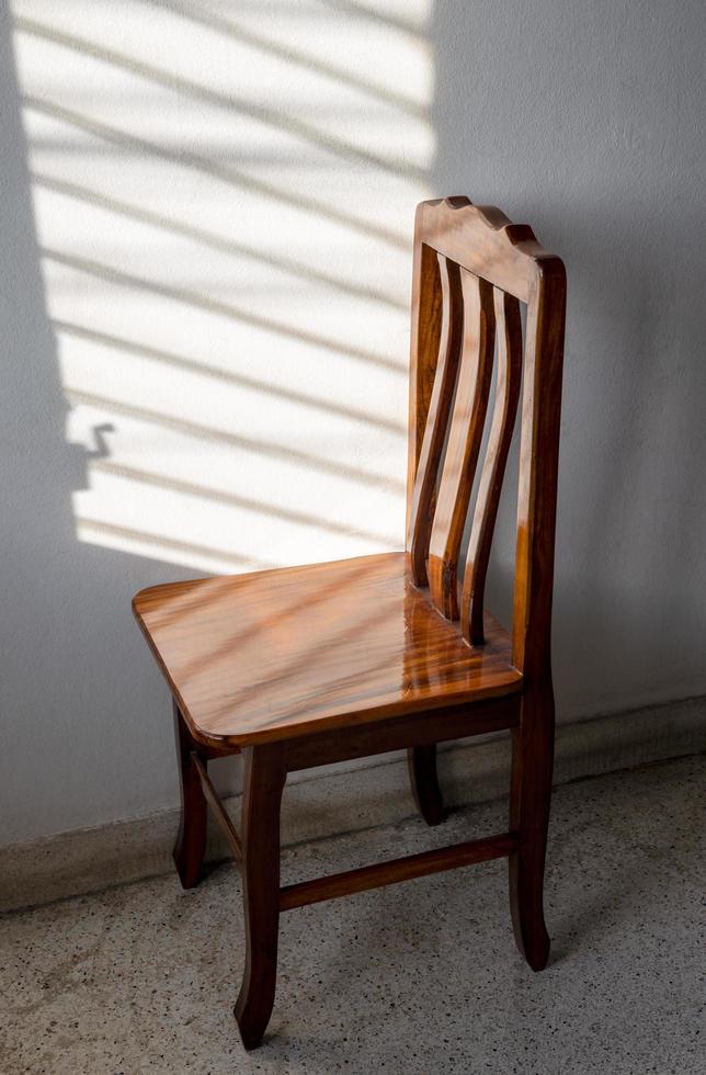 cadeiras de madeira e a luz do sol através das janelas fechadas nas paredes da sala. foto