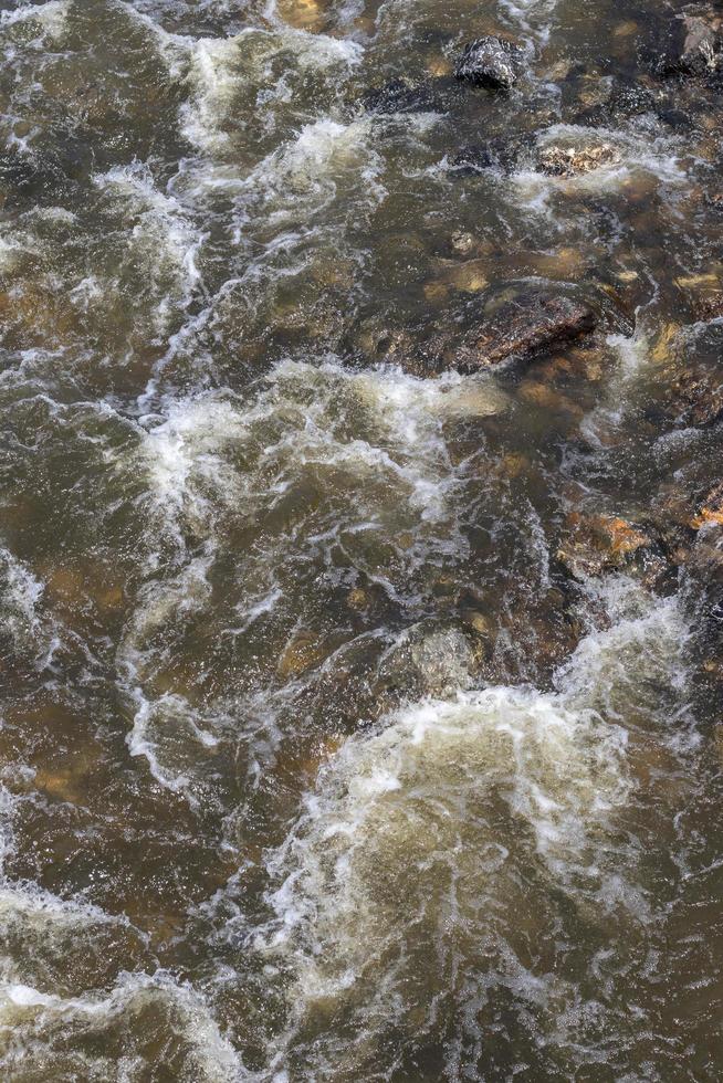 a água flui em riachos com muitas rochas de granito. foto