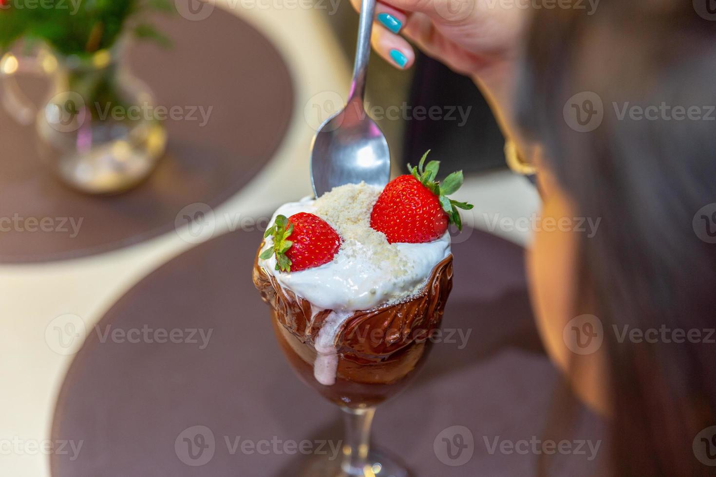 sorvete branco mistura morango com altas calorias, pode engordar, foco suave, desfocado. delicioso sundae de baunilha ou chocolate com morango. foto