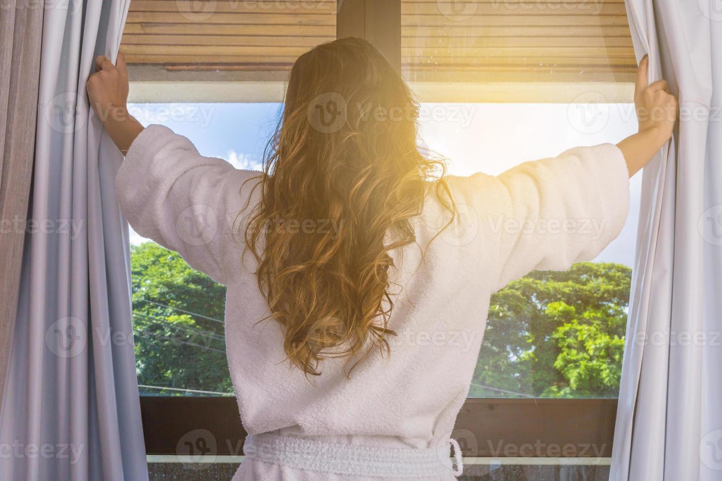 pessoas e conceito de esperança - close-up de mulher feliz abrindo cortinas de janela foto