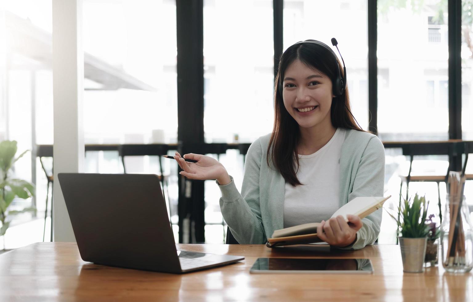 conceito de educação online e-learning. mulher asiática estudante atento por videoconferência e-learning com professor no computador portátil em casa foto