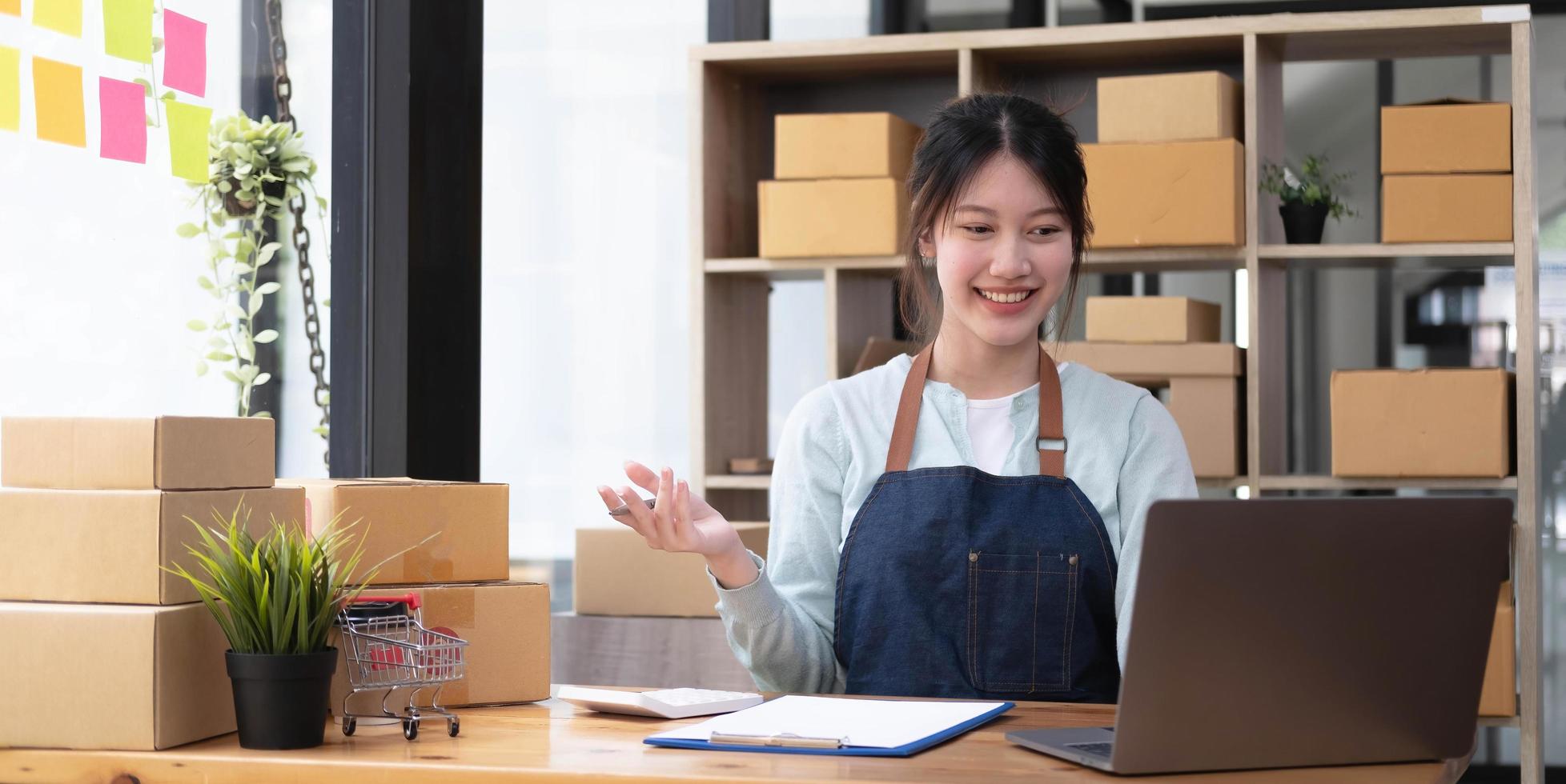 retrato de começar pequenas empresas proprietárias de pmes empresárias trabalhando na caixa de recibo e verificar pedidos on-line para se preparar para embalar as caixas, vender para clientes e ideias de negócios de pmes online. foto