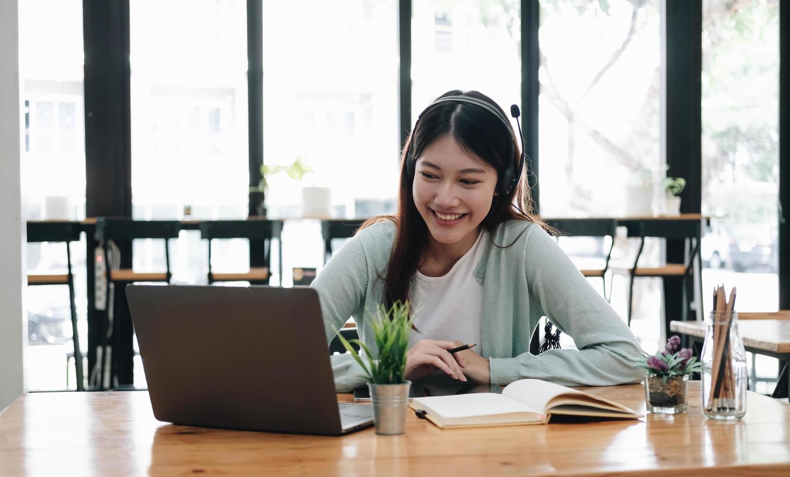 conceito de educação online e-learning. mulher asiática estudante atento por videoconferência e-learning com professor no computador portátil em casa foto