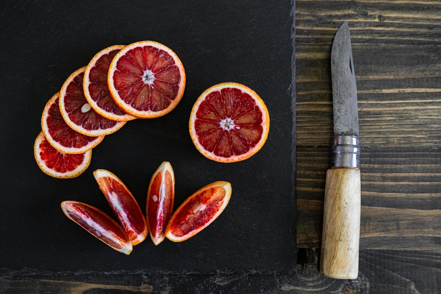 fatias de laranjas sicilianas ou sangrentas em um fundo de ardósia preta foto