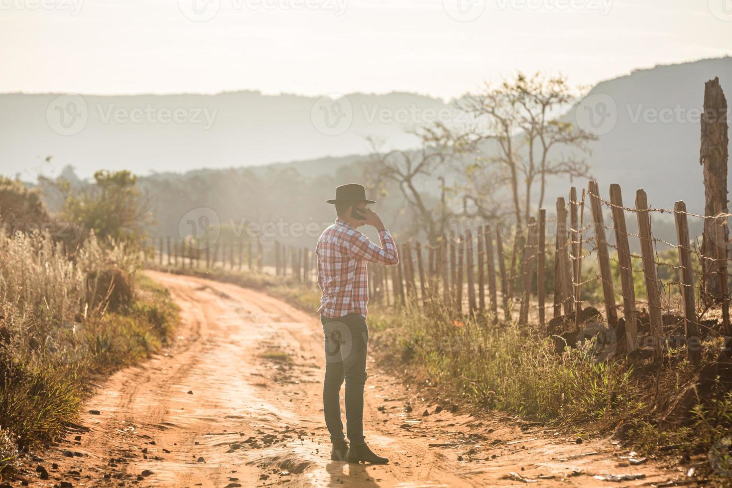 agricultor ou homem do campo usando um smartphone na fazenda. agricultor internet 4g. redes sociais, consultas online. foto