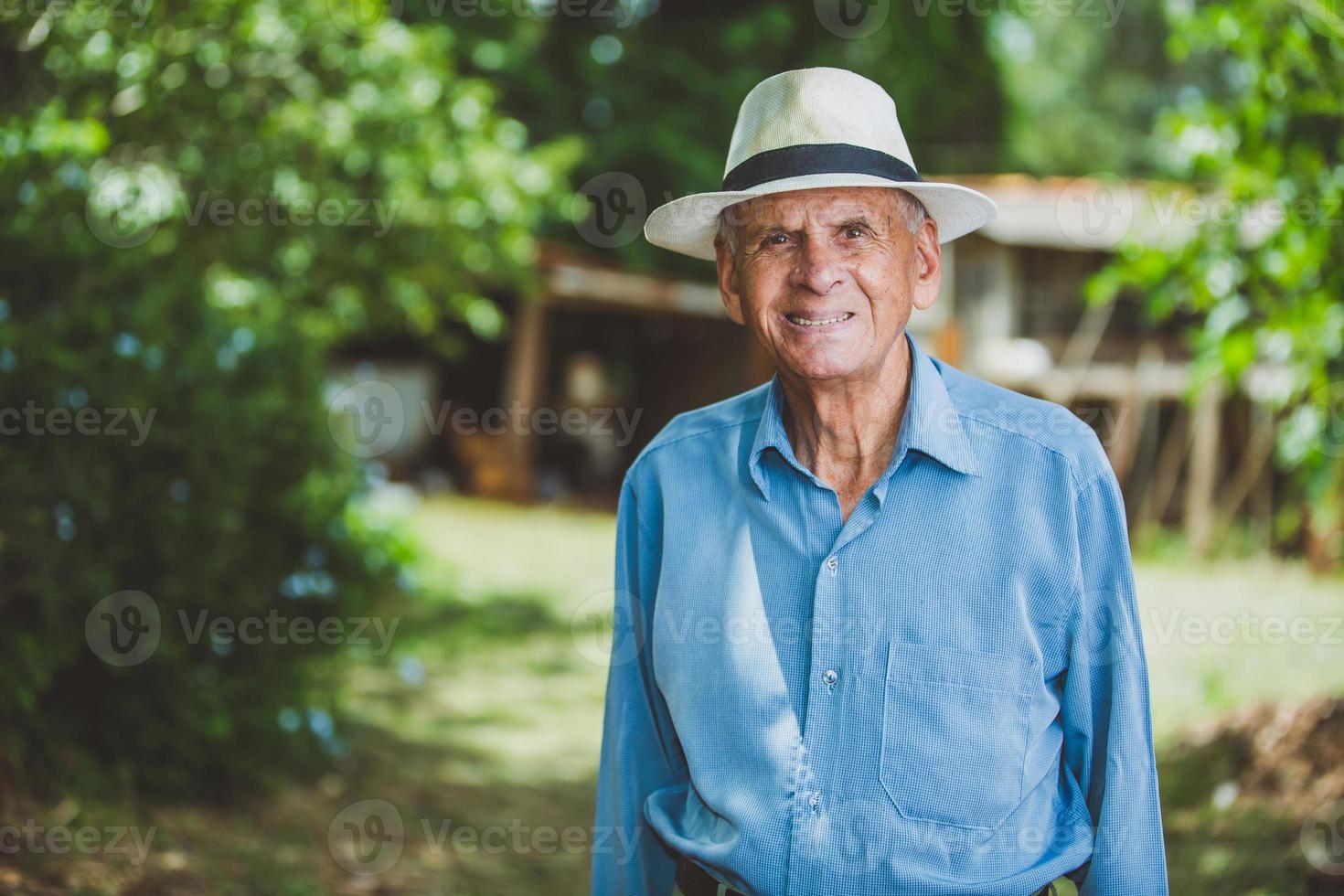 retrato de sorrindo lindo agricultor masculino mais velho. homem idoso na fazenda em dia de verão. atividade de jardinagem. homem idoso brasileiro. foto