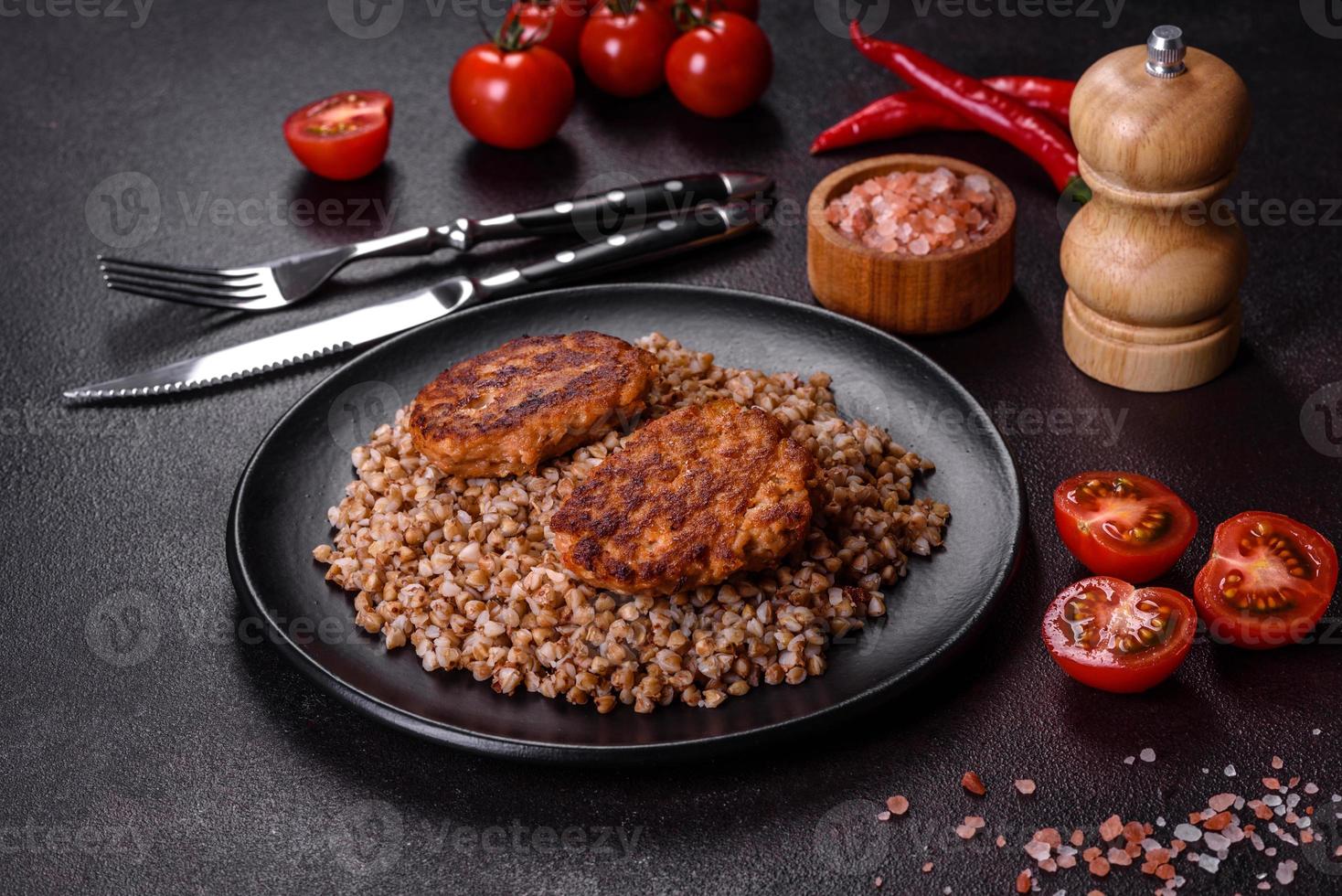 delicioso mingau de trigo sarraceno cozido fresco com legumes e especiarias em um prato preto foto