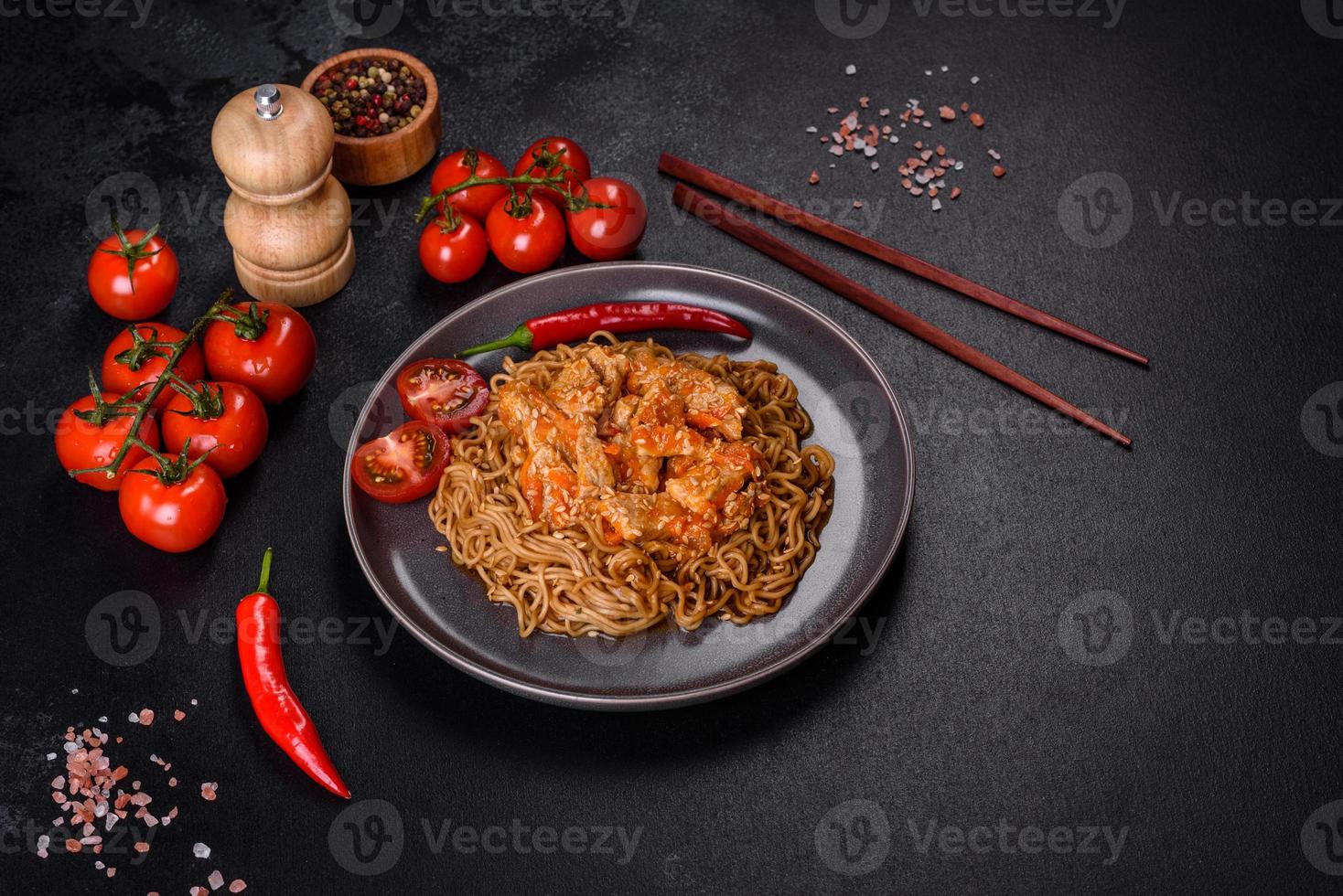 prato de macarrão e frango tailandês em um fundo preto de concreto com pauzinhos chineses e espaço de cópia foto