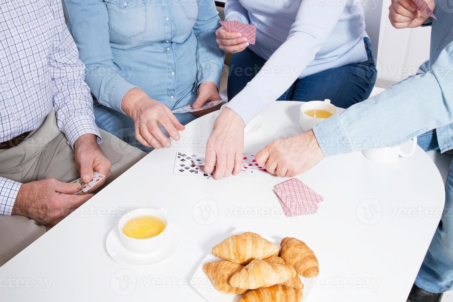 casal de idosos jogando cartas com as mãos da família close-up foto