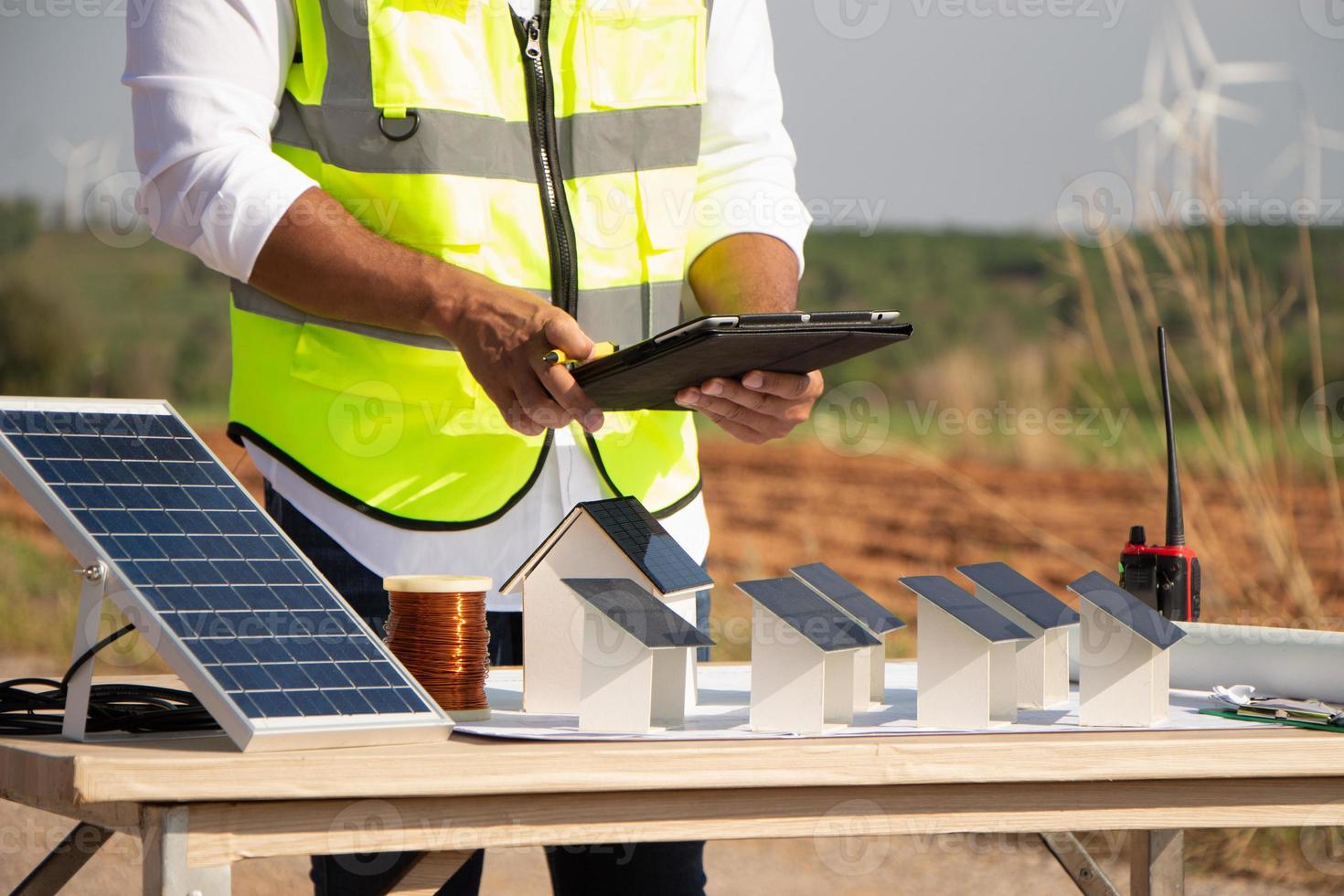 equipe de engenheiros trabalhando em fazenda de turbinas eólicas e células solares. energia renovável com gerador eólico pelo conceito de energia alternativa. foto