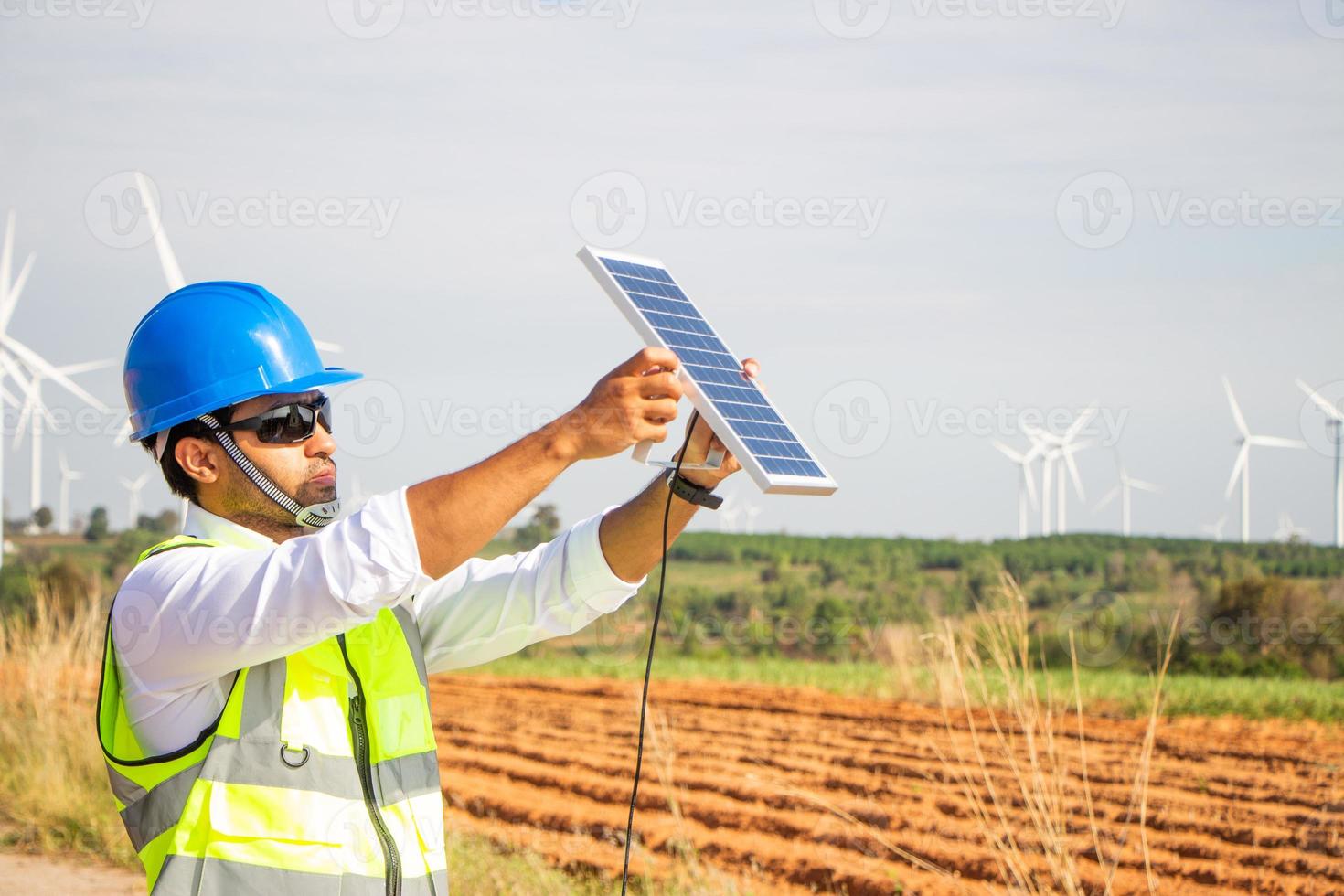 equipe de engenheiros trabalhando em fazenda de turbinas eólicas e células solares. energia renovável com gerador eólico pelo conceito de energia alternativa. foto