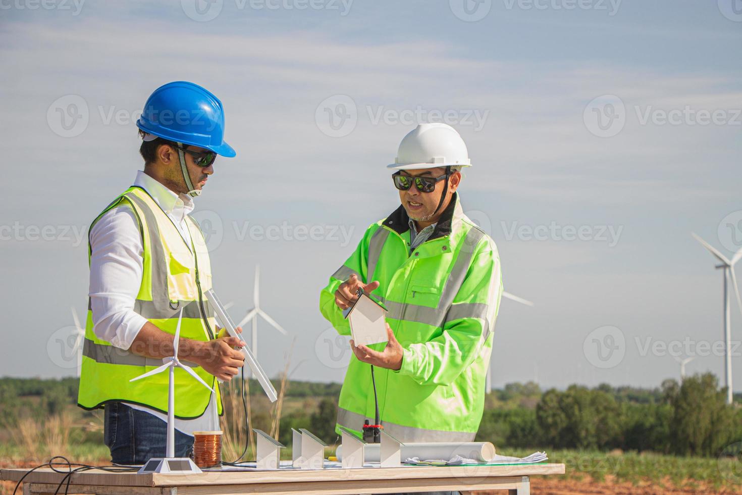 equipe de engenheiros trabalhando em fazenda de turbinas eólicas e células solares. energia renovável com gerador eólico pelo conceito de energia alternativa. foto