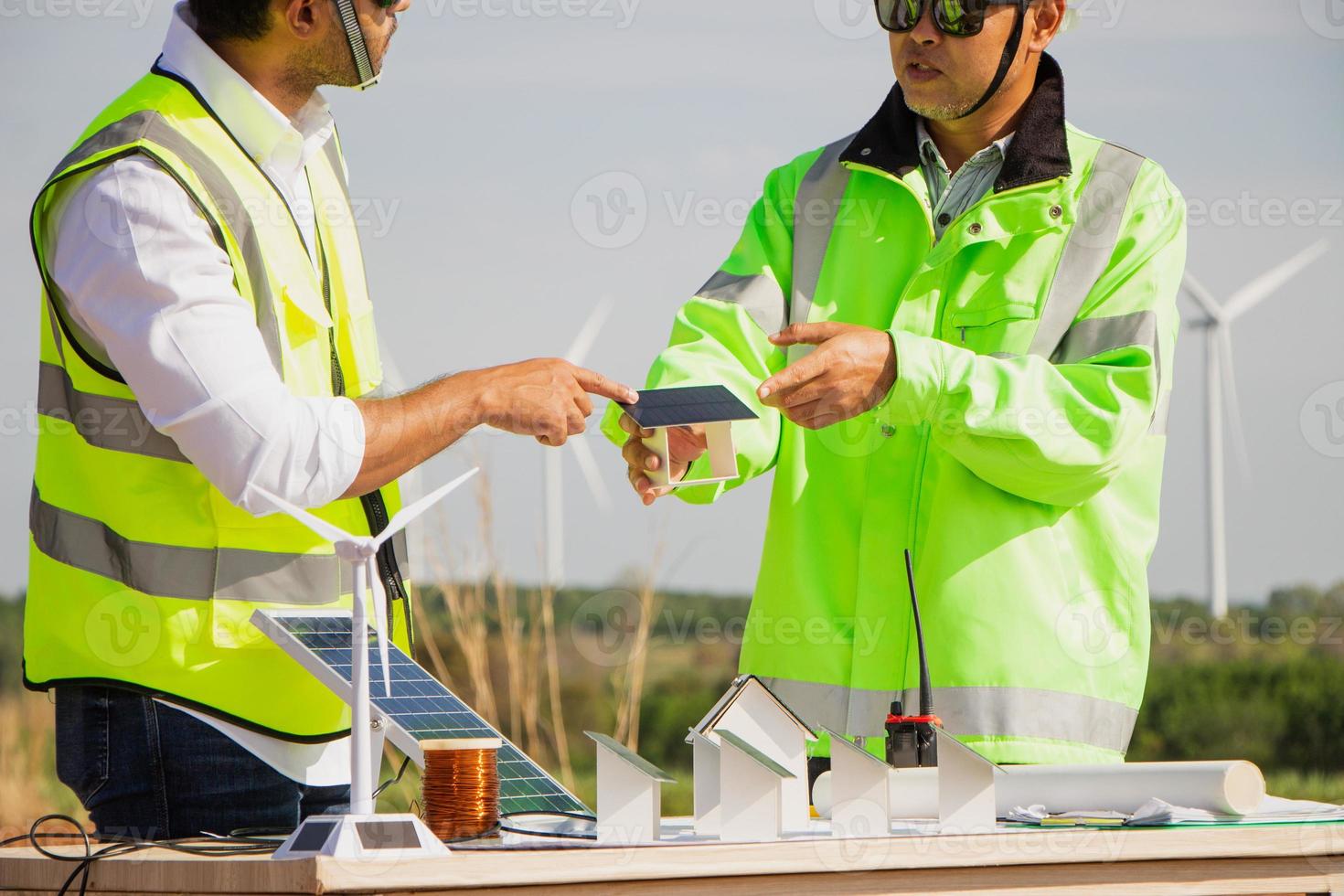 equipe de engenheiros trabalhando em fazenda de turbinas eólicas e células solares. energia renovável com gerador eólico pelo conceito de energia alternativa. foto