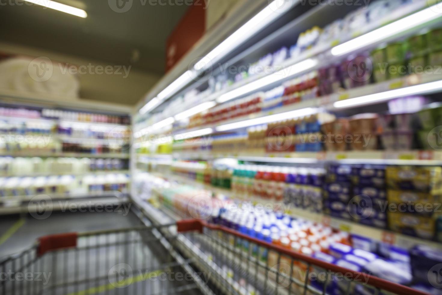 o borrão desfocado da bebida, leite, comida, carrinho de compras, colocado em uma prateleira na bebida. foto