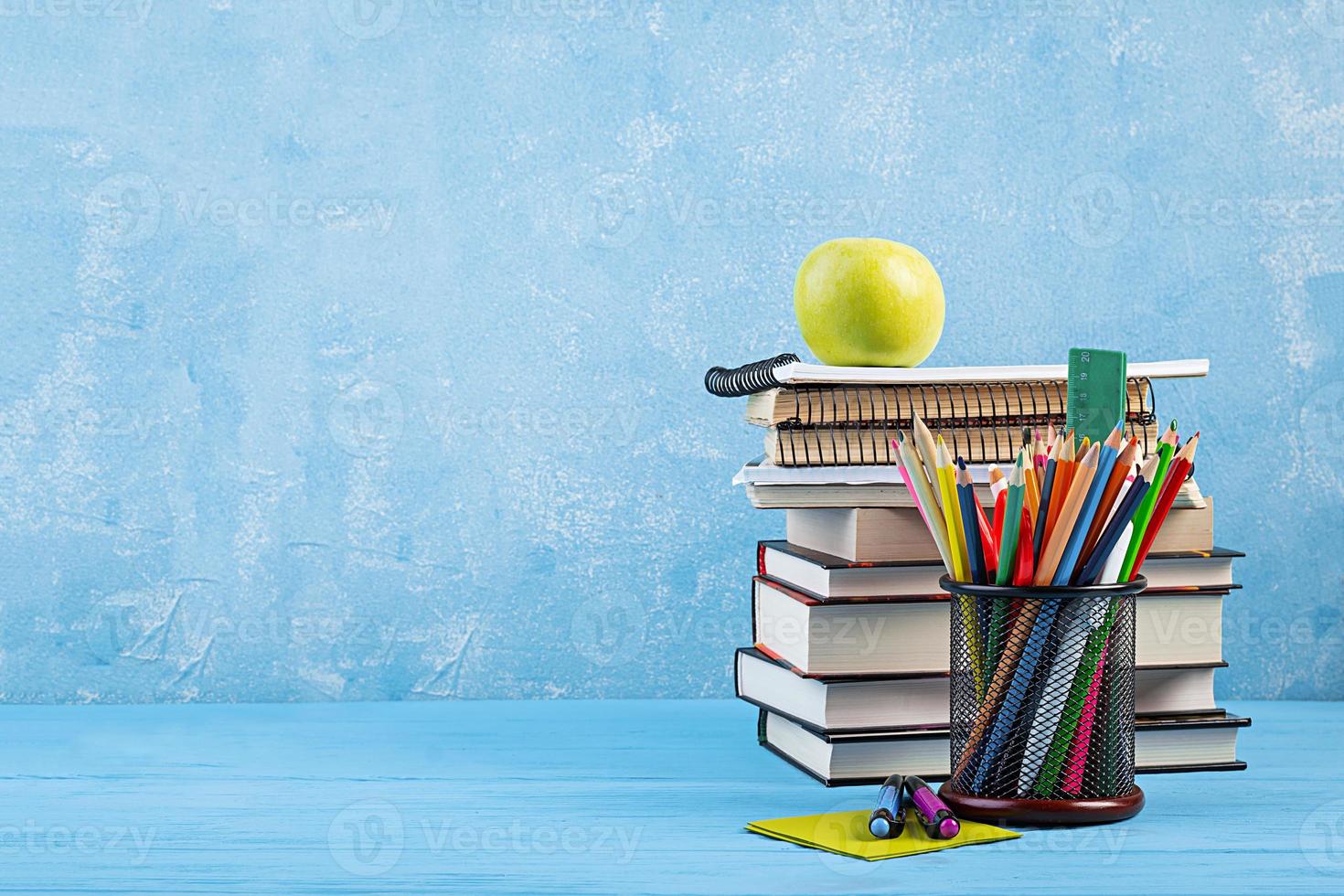 conjunto de material escolar colorido, livros e cadernos. acessórios de papelaria. foto