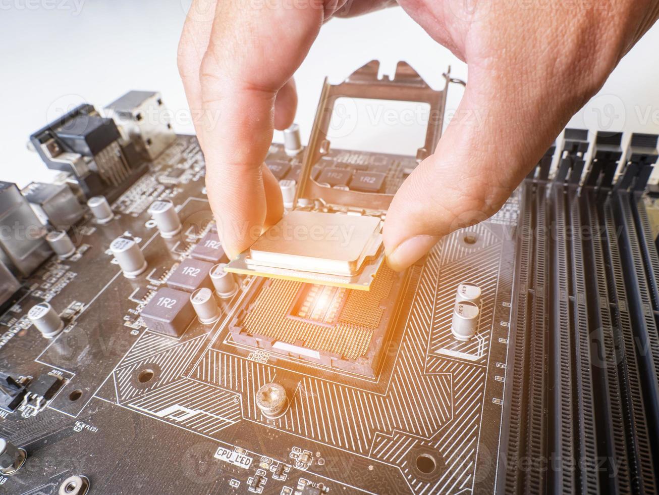 segure a alça da CPU e insira-a no slot da CPU na placa-mãe. é uma placa-mãe velha, muita poeira. coloque a luz laranja no slot da CPU. há um slot de ram próximo a ele. existe um condensador. foto