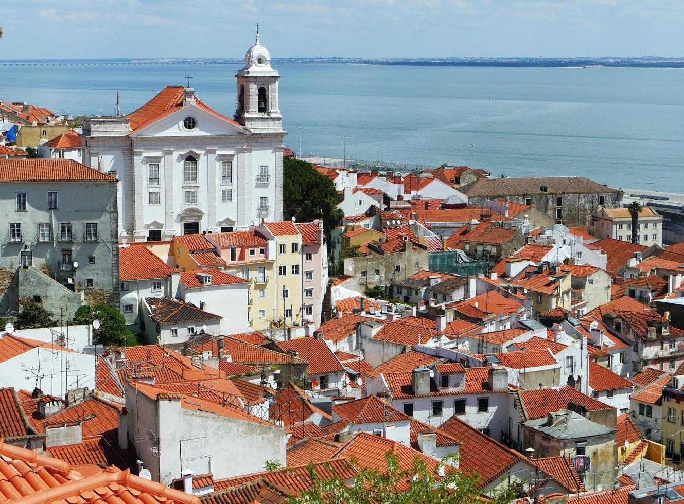 vista superior telhados históricos vermelhos edifícios brancos e rio tejo da cidade de lisboa portugal foto