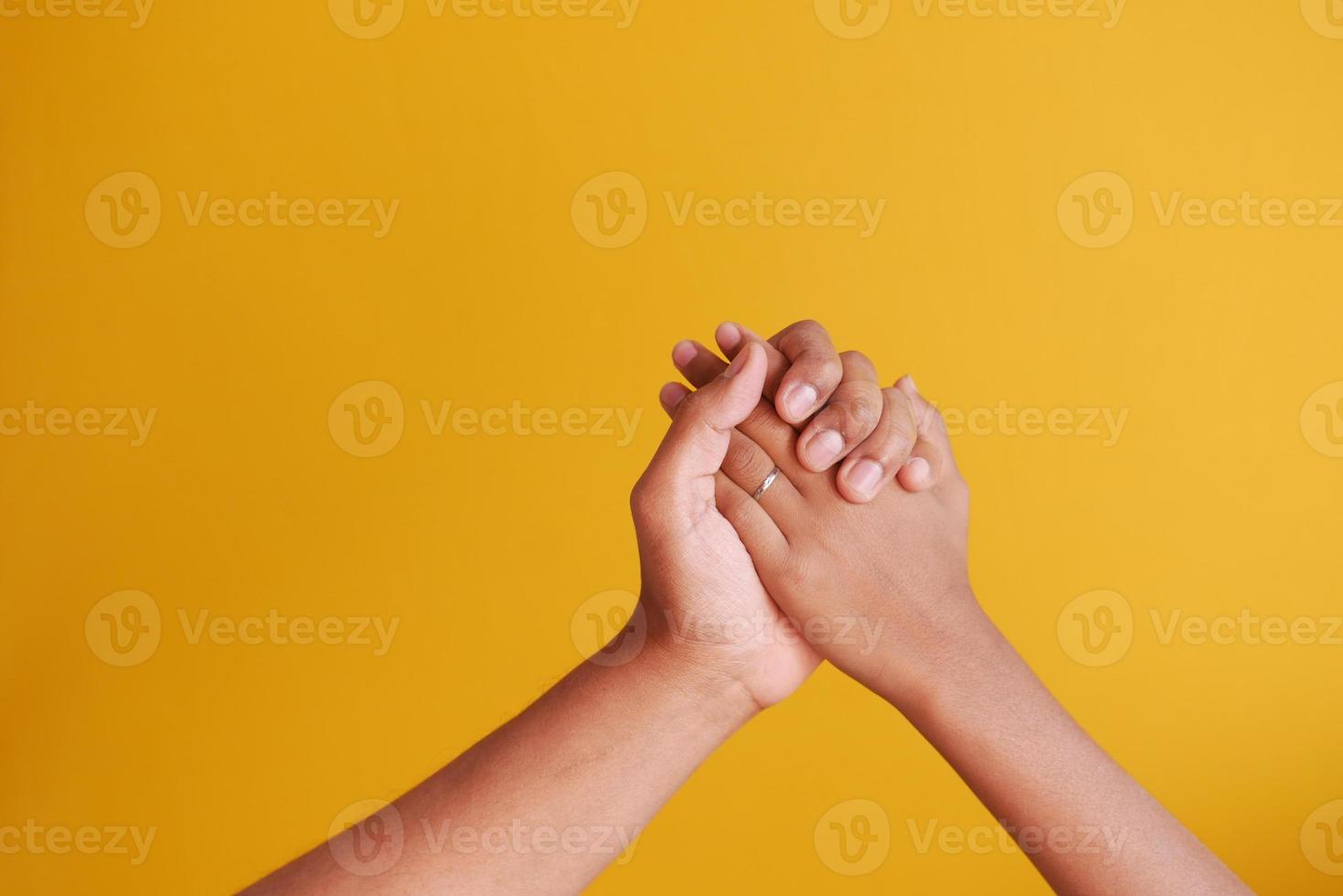 pai segurando sua mão de menino filho no fundo amarelo foto