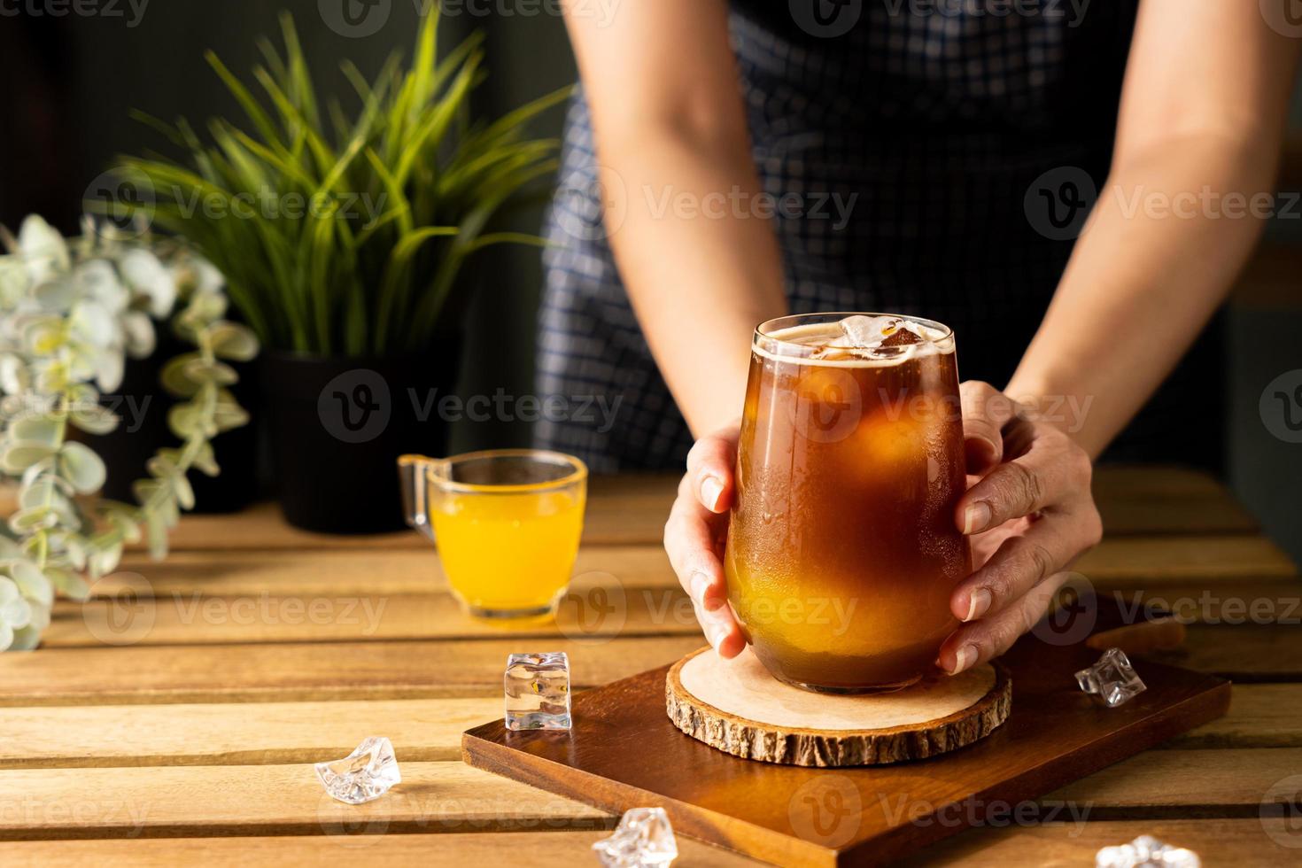 copo de café expresso com suco de laranja na mesa de madeira e espaço de cópia, coquetel de verão, café frio ou chá preto foto