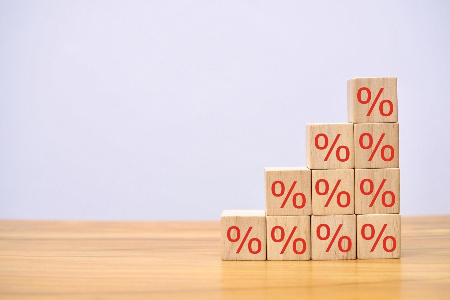 conceito de taxas de juros em finanças e empréstimos. bloco de cubo de madeira acima com símbolo de porcentagem. foto