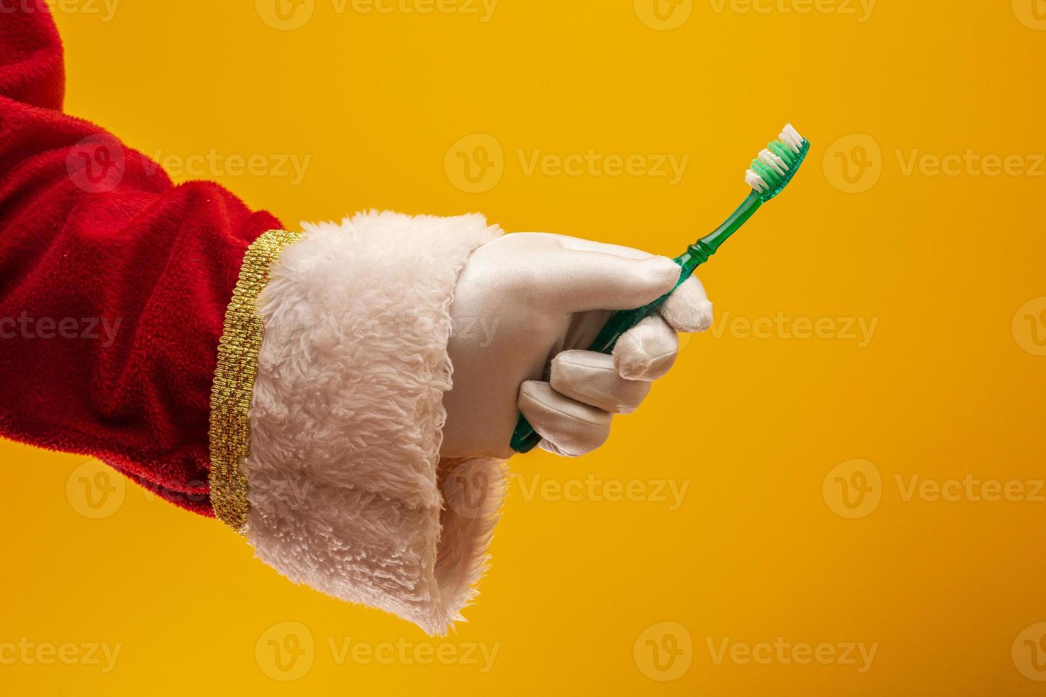 mão de papai noel com escova de dentes foto