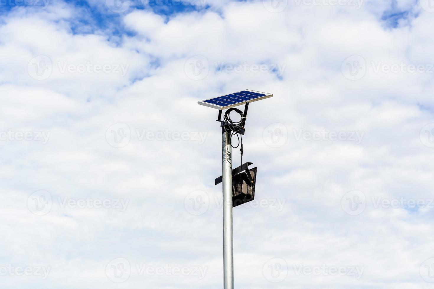 pequeno painel solar para luz na rua ou parque com nuvens brancas e céu azul. poste de iluminação ao ar livre com energia de painel solar de tamanho pequeno por si só, nova tecnologia e tendência de energia para área pública foto
