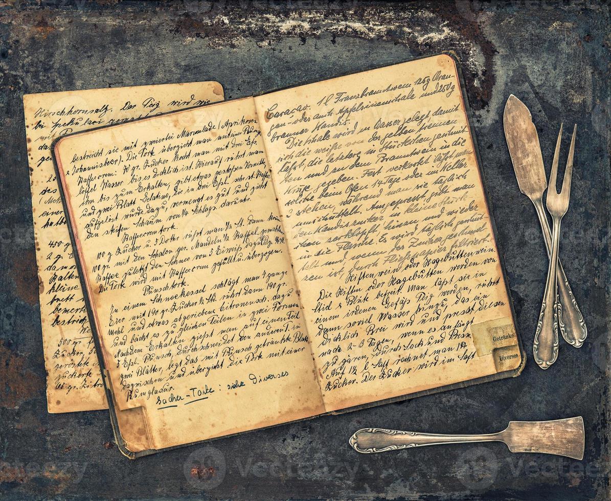 talheres antigos e livro de receitas manuscritas vintage foto