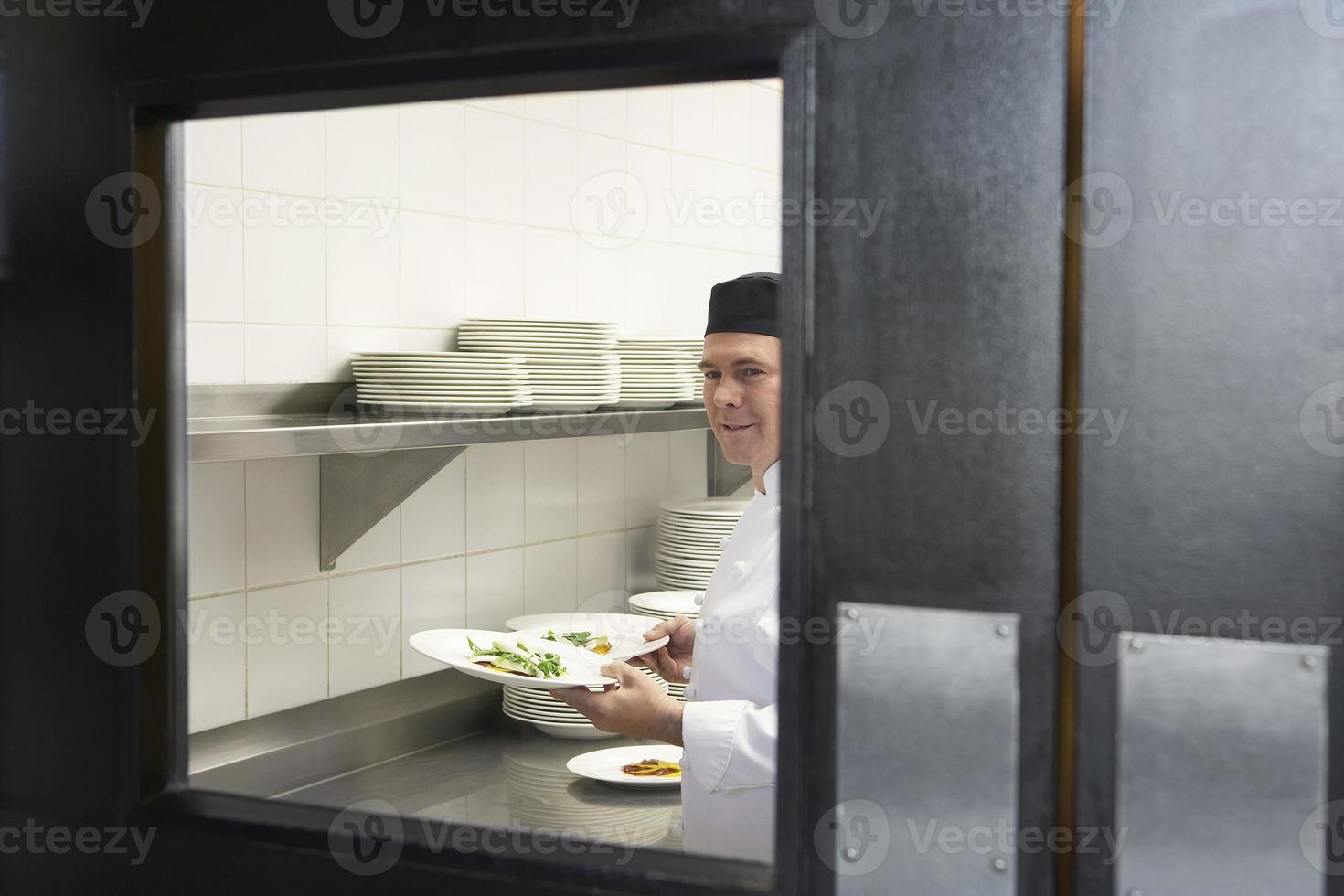 chef masculino com pratos de comida na cozinha foto