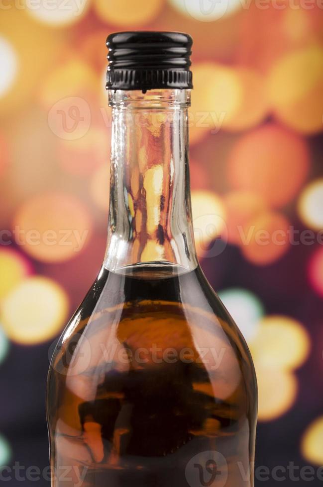 garrafa de uísque de rum sobre fundo desfocado luzes foto