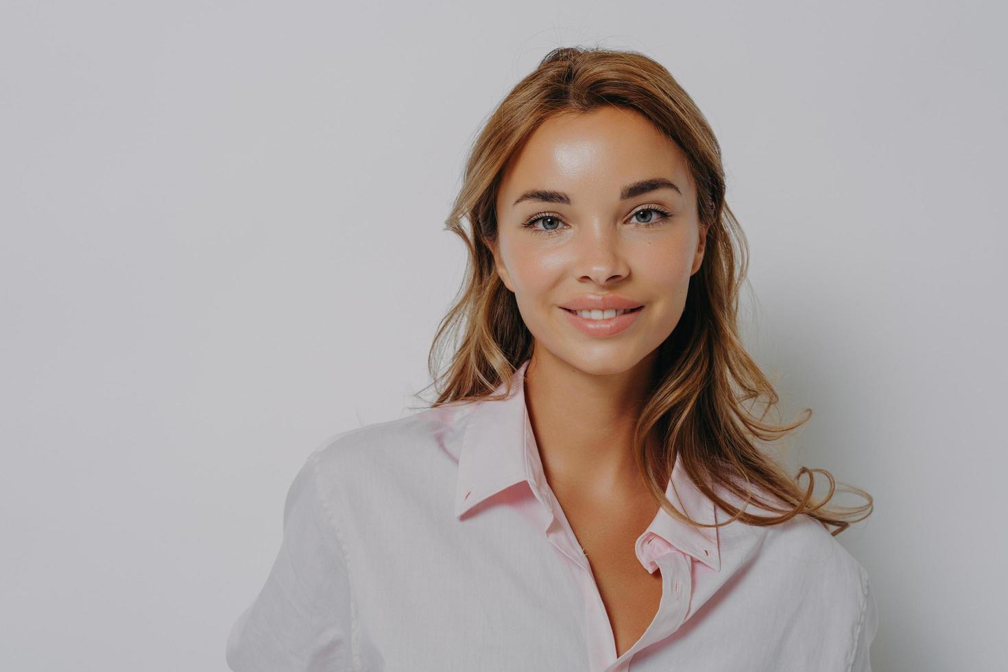 retrato de close-up de linda mulher loira atraente com olhos azuis brilhantes, em camisa casual foto