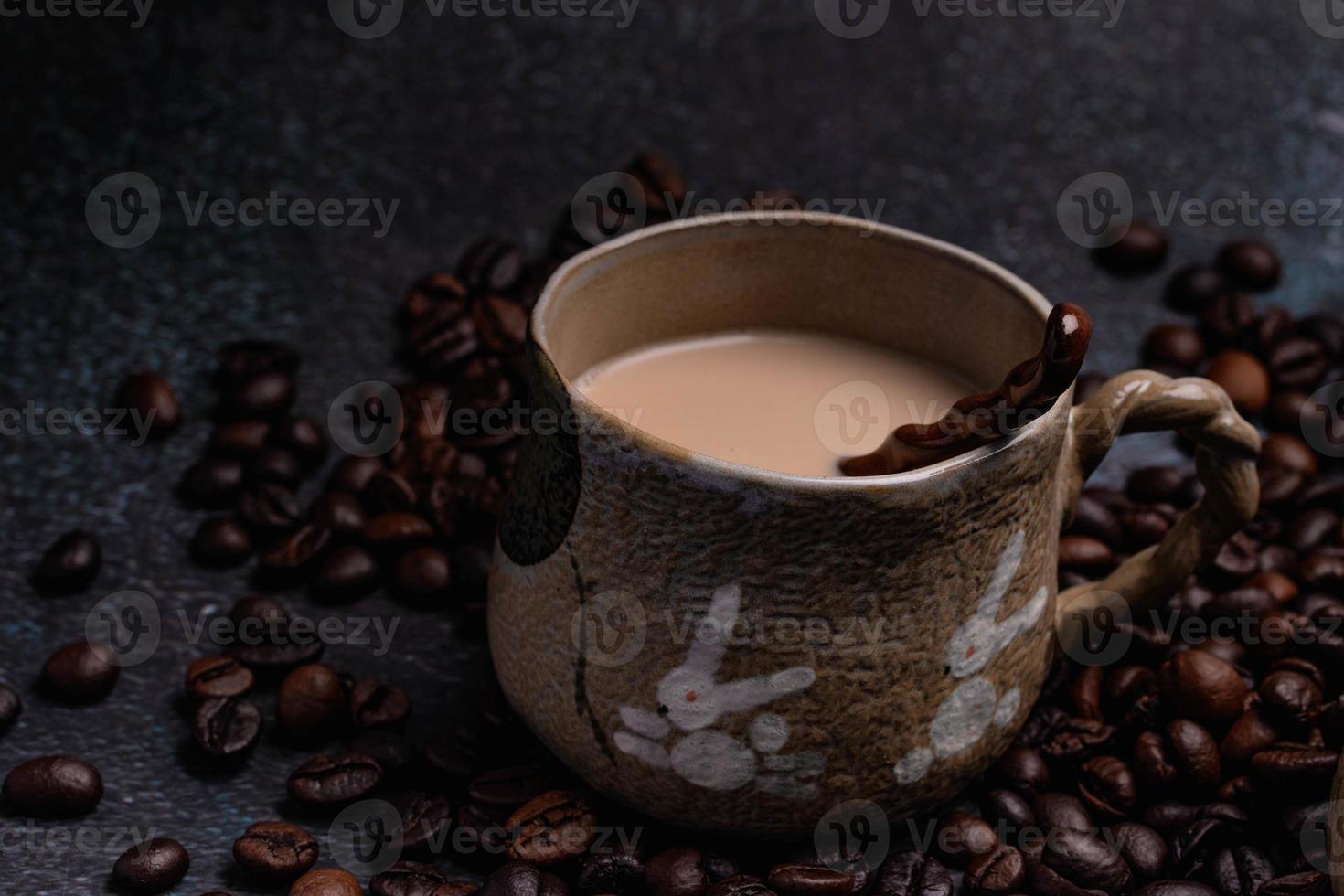 duas canecas de café com grãos de café em um pano de fundo escuro. foto