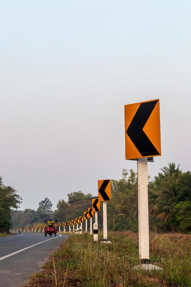 sinais de trânsito curvos com estradas rurais. foto