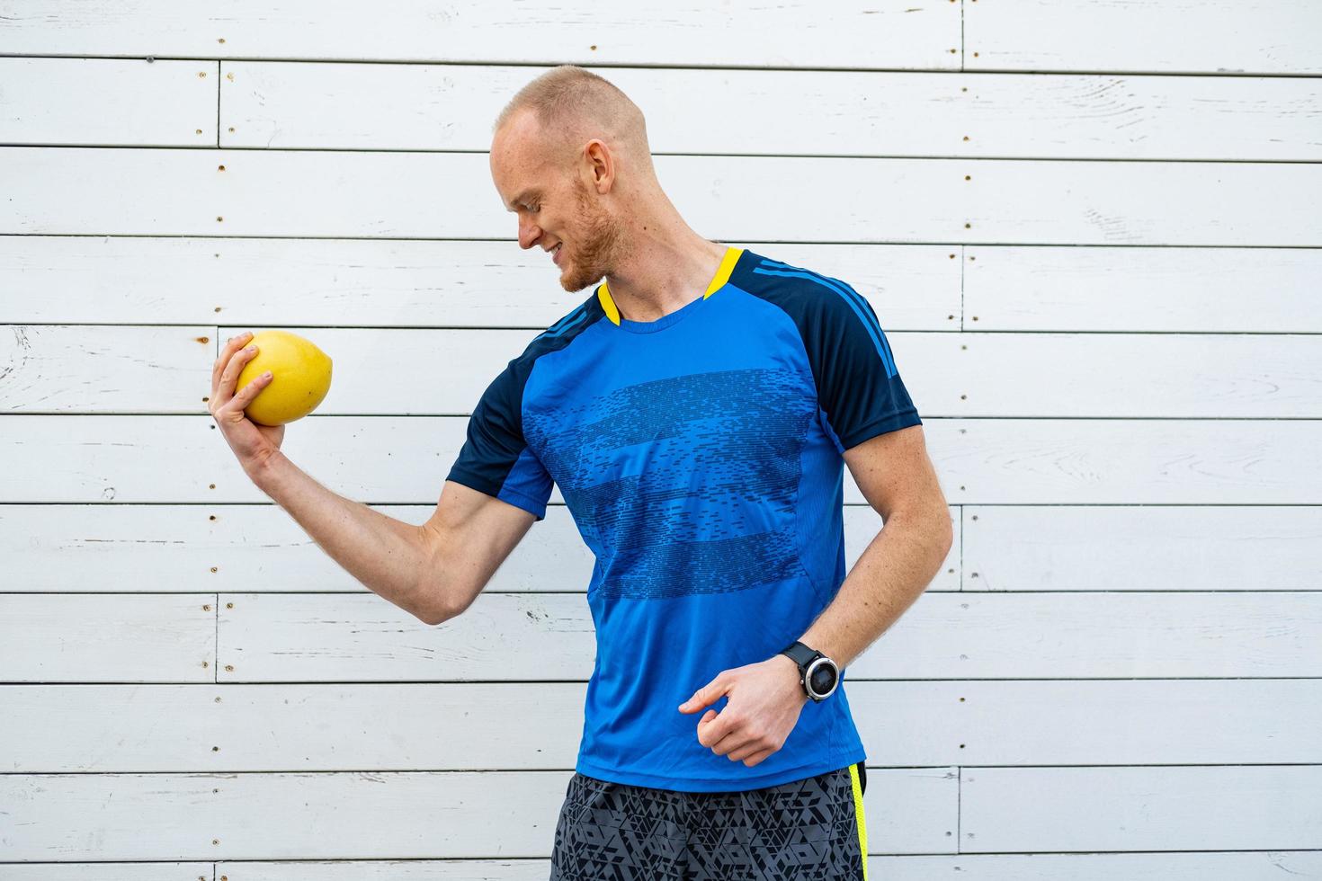 feliz jovem atleta masculino com toranja na mão foto