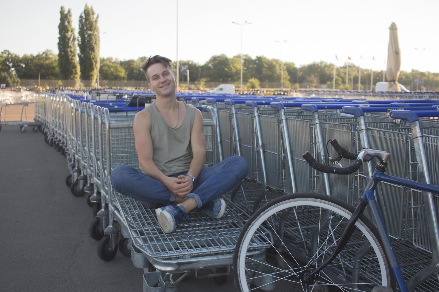 jovem, homem anda com bicicleta fixa, meio urbano, foto de hipster com bicicleta nas cores azuis