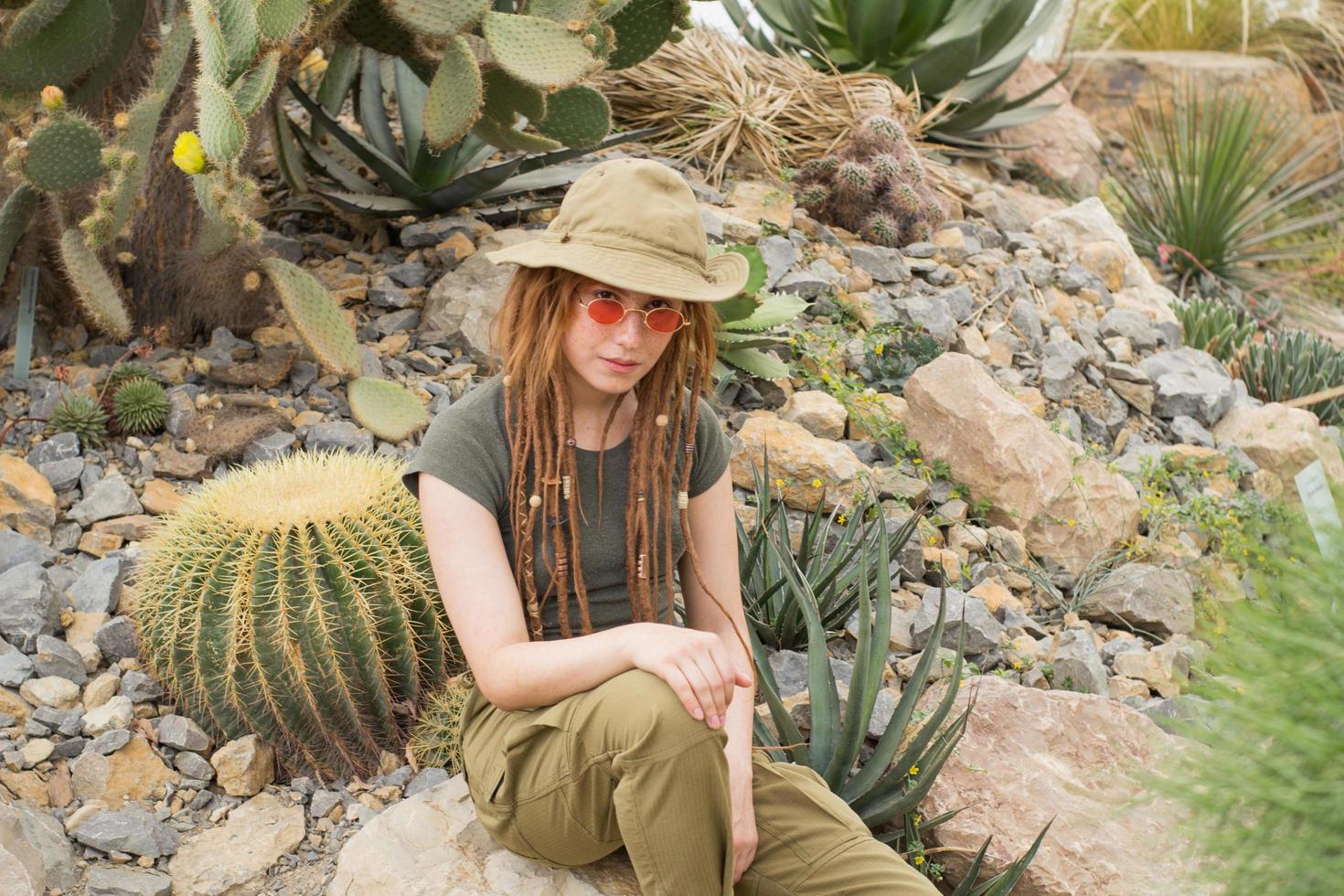 jovem viajante masculino no deserto, mulher alpinista no jardim de cactos foto