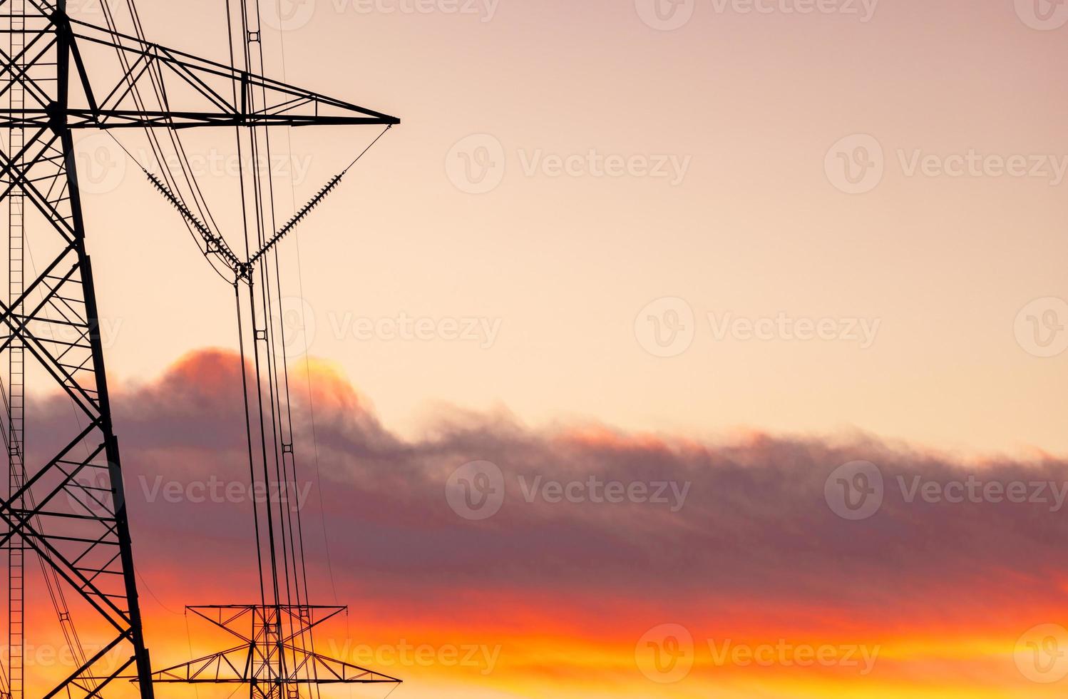 poste elétrico de alta tensão e linhas de transmissão. postes de eletricidade ao pôr do sol com céu laranja. potência e energia. conservação de energia. torre de grade de alta tensão com cabo de arame na estação de distribuição. foto