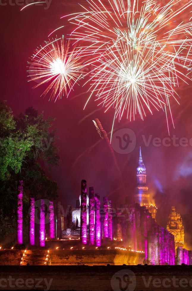 fogos de artifício coloridos com o antigo templo de sukhothai à noite. foto