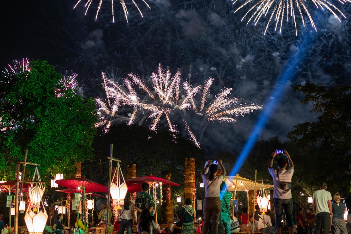 fogos de artifício sobre as árvores e as pessoas no festival. foto