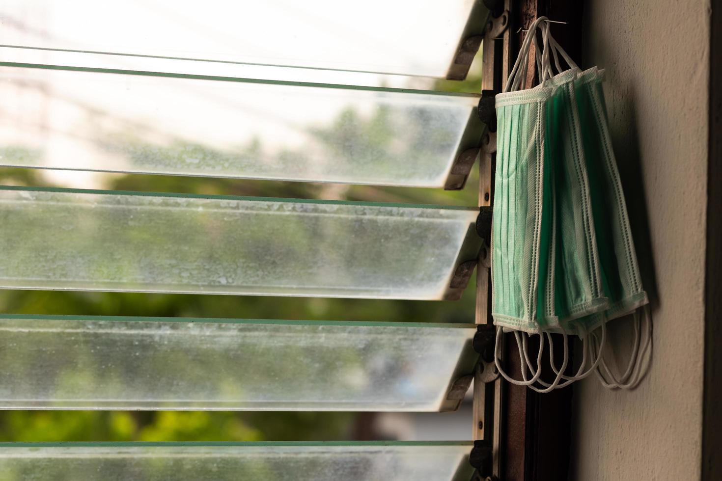 muitas máscaras sanitárias penduradas nos caixilhos das persianas. foto